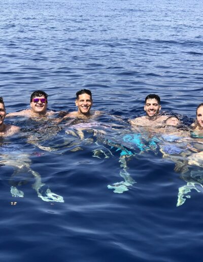 Grupo de amigos disfrutando de un baño en altamar en Benalmádena, nadando y divirtiéndose en el mar