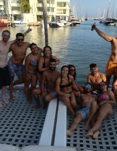 Grupo de amigos disfrutando de una salida en barco en Benalmádena, navegando y divirtiéndose bajo el sol